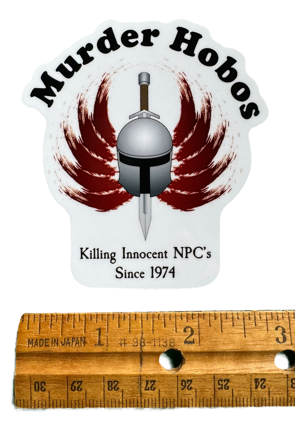 A bold, chaotic design built around dark fantasy humor and reckless adventure energy. The words:

“Murder Hobos – Killing innocent NPCs since 1974.” with a ruler for size validity