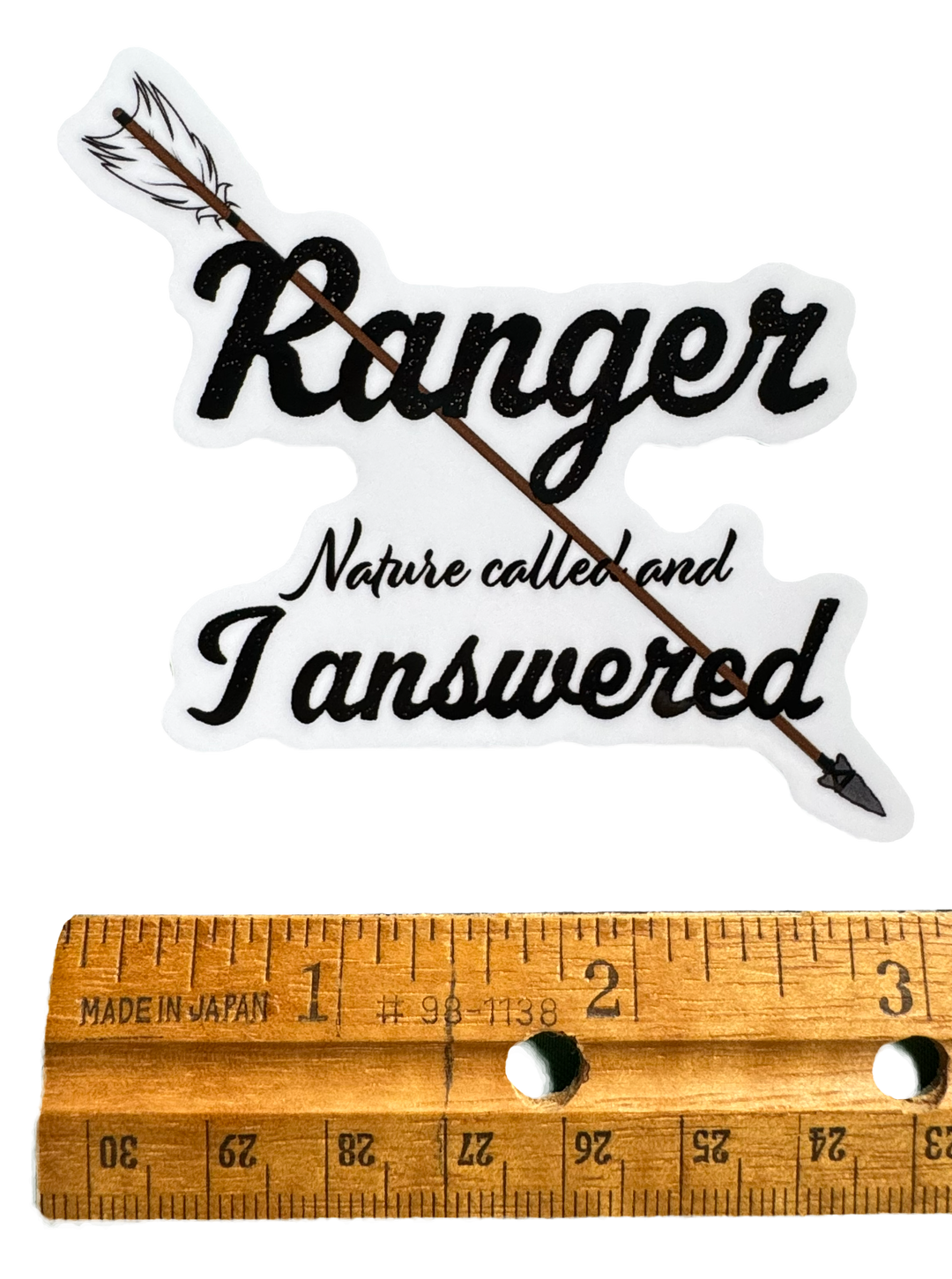 The word Ranger stands strong at the center in grounded, confident typography — clean but powerful. Cutting through the design is an arrow that runs horizontally through the words, reinforcing purpose and action. The arrow adds movement and direction, with a defined arrowhead and detailed fletching that make it feel ready to fly.

Below or integrated with the layout sits the phrase:

“Nature called and I answered.”
with a ruler for size validity